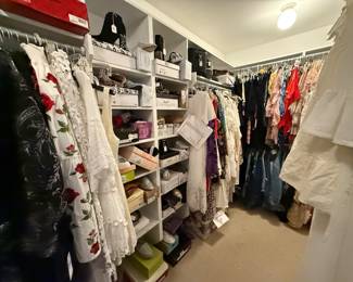 Closet full to the walls with shoes still in boxes and clothes with tags