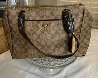 Coach Brown and tan canvas with black leather trim handbag. Price reflects light wear on one side of top zipper $40 excellent condition 