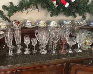 Crystal Left to right: set of 4 Waterford Lismore champagne flutes $60. Set of 2 Waterford Kildare sherry glasses $20. Set of 3 Mikasa Ridgeline Mugs with handles $24. Set of four 9” wine glasses with NOEL on the stems $20. Swirl optic wine glasses with pink frosted stems $24. Atlantis 2 sets  of 6 wine glasses and champagne/sherbert glasses. Each set $30. Also available is an assortment of 7 cake plates to highlight your decorations or for cake/cupcakes