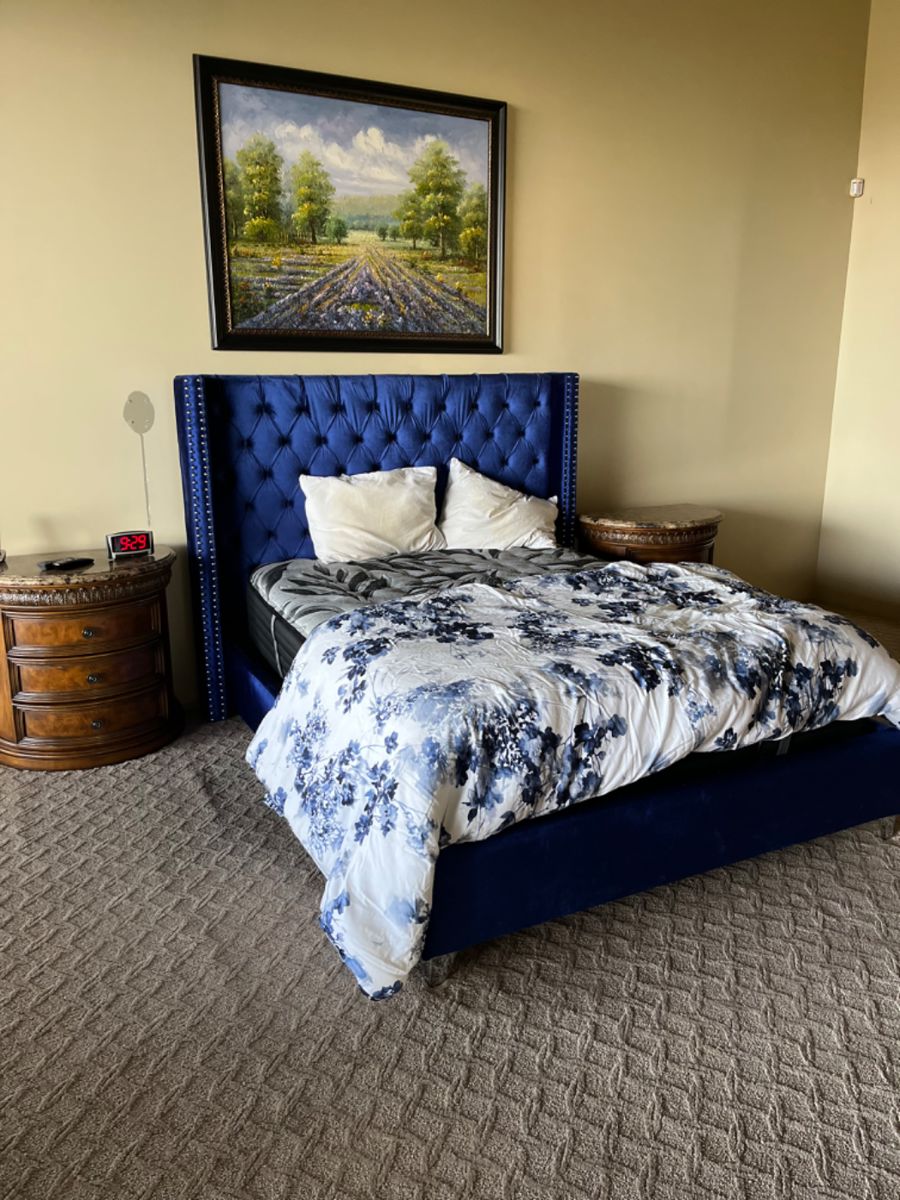This bedroom is beyond gorgeous! Look at the beautiful blue tufted headboard and the drum nightstands with marble tops.