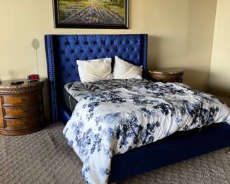 This bedroom is beyond gorgeous! Look at the beautiful blue tufted headboard and the drum nightstands with marble tops.  