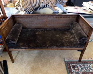Caned angular settee with plush seat and side pillows 