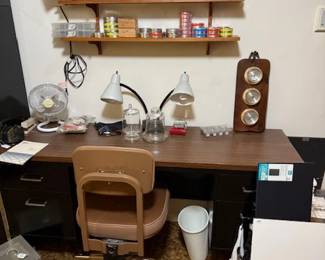 Long narrow metal desk and rolling chair many pellets some match