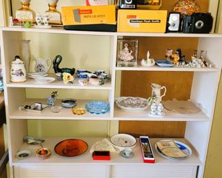 Mid-century book shelf - Kodak Brownie cameras and Development kit.  Miniature cats and dogs, decorative plates, ash trays and more