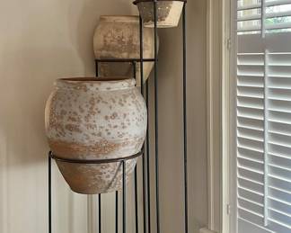 Massive Terra cotta pots on custom iron stands.