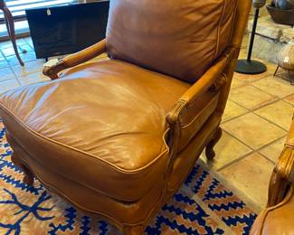 One of a pair of nice leather occasional chairs, each with an ottoman.  