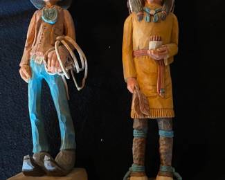 Carved wooden cowboy and indian figures.
