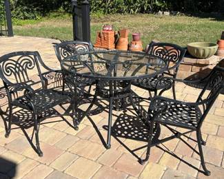 Wrought iron glass top outdoor table w/4 seats.