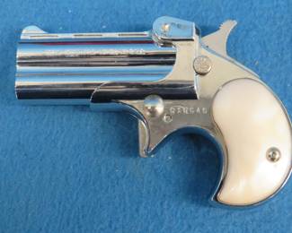 Lot 27. Davis Model D-25 .25 auto pistol in velvet lined wooden box. SN 10640. Chrome-plated with faux pearl grips.