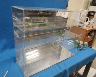 Lot 280. Pexiglass cabinet with four shelves, mirrored back and bottom, and a hinged door to keep out the dust 30"W x 24"H x 10 1/2" D