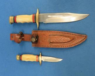 Lot 51. Matched set of Timber Rattler knives with stainless steel blades and a leather sheath.
