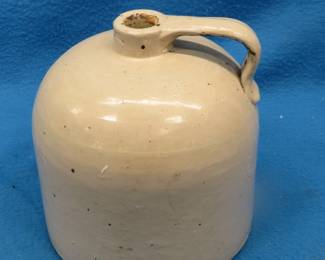 Lot 121. Old one-gallon stoneware jug with illegible markings on the bottom and a tight crack in the handle