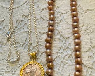 several strands of real pearls and a large .999 silver coin with a sterling long chain