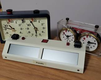 Multiple chess timers including a Chronos Samtime chess timer.