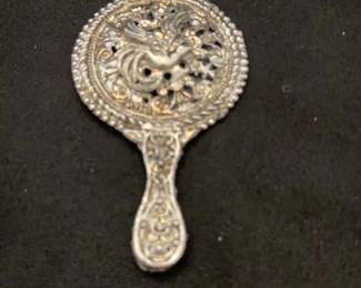 Silver tone hand mirror with filigree work and bird in the middle from one side