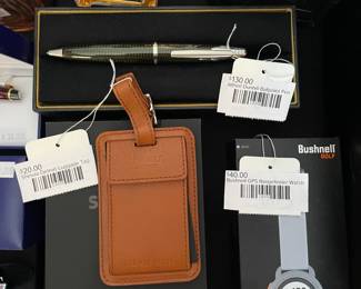 Shinola Detroit luggage tag, Bushnell GPS rangefinder watch, Alfred Dunhill ballpoint pen