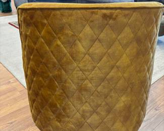 The back and side of the gold velvet chairs are quilted