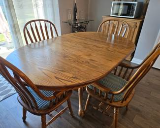 Oak dining table with four chairs with arms