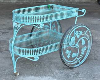 MID-CENTURY PATIO BAR CART | Cast iron bar cart with two glass shelves, having scrollwork and intricate vine design wheels. - h. 32 x w. 26 x l. 45 in

