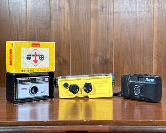(3pc) Film Cameras | Including a Kodak Instamatic 104 / Camera with original box, a yellow Minolta Weathermatic A camera, and a Hachi focus free 35mm film camera.