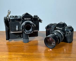 (2pc) Nikon 35mm Cameras | Nikon SLR film cameras including a Nikon N2000 and a Nikon on a Polaroid proback by forscher.
