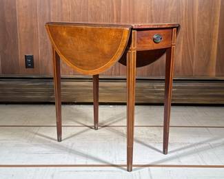 Pembroke Table | Inlaid in contrasting woods, having an extending round top over square tapering legs, with a single drawer; each leaf w. 9.5 in. - h. 27.75 x w. 16.25 x l. 24.5 in (sides down)