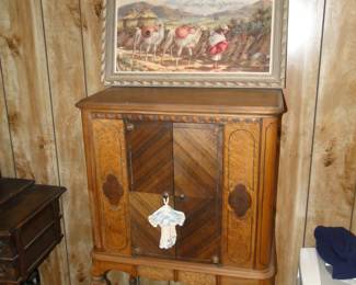 A very nice piece of hand painted artwork, and vintage cabinet