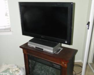 Small electric fireplace holding a flat screen TV