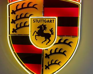 Illuminated Neon Porsche Crest (44" x 36" x 8").  With vibrant gold, white, and red neon, the Porsche logo is a combination of the Stuttgart coat of arms, which features a leaping horse, and the state coat of arms of Wurtemberg, established in 1933.