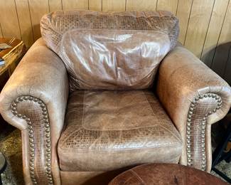 brown leather club chair with rolled, nailhead arms