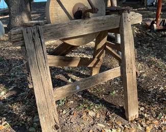 antique grindstone sharpener on wooden stand