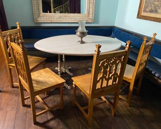 football shaped marble table on four cat iron base, large upholstered L shape seating bench