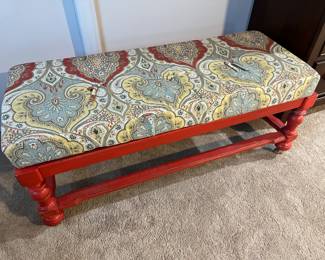 Vintage shabby chic bench with cushion, painted red.