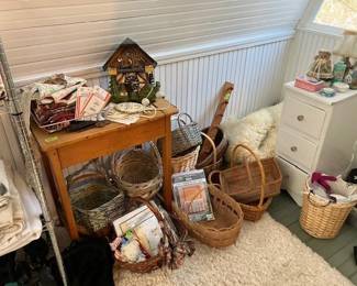 Another antique school desk, assorted baskets, cuckoo clock, wallets and small white bedside drawers.