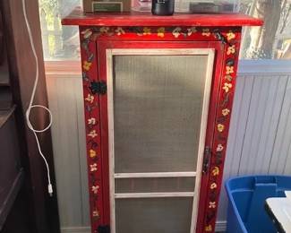 Red wooden small cupboard with screen front