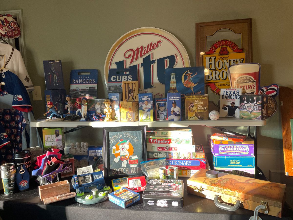 A room filled with Texas Rangers memorabilia, Beer advertising signs, sports shirts, vintage games, electronics and more 