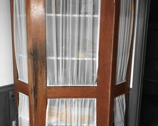 Primitive corner cabinet. Built by owner's grandfather for a general store in the mid to late 1800's. We are not sure if it originally had tin or glass inserts in the doors or was left open for display. It currently has curtains to protect the contents from light. It is very sturdy and would be great for housing canned goods or emergency provisions.