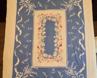 Beautiful 1950's Tablecloth in near perfect condition. Approximately 64" x 50". Blue & white, lily of the valley. Shades of pink to red daisies surrounding the center. Colors are bright and no wear, flaws nor stains noted. There is a small, faint "10" on the back of one corner. It has been laundered with our signature LeBlanc Linen Wash. Item has not been ironed as to not "set" any missed stains. (Honestly it dried mostly wrinkle-free. A quick press of a few fold-overs on the border would be fine for me to use (and I'm rather picky)!