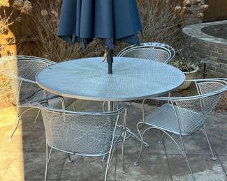 Silver painted wrought iron outdoor table with seating for four and umbrella