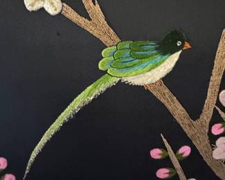 Close-up view of needlepoint art with gold thread