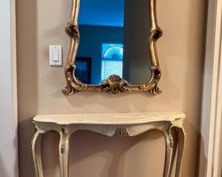 Gold wall mirror and marble top accent table