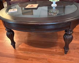 Round dark wood coffee table with glass top