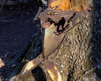 Metal sculpture of a cowboy frog playing  guitar
