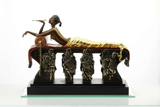 A “Glamour in Bronze” series Art Deco bronze sculpture by the father of the Art Deco movement, the immortal Erte (Romain de Tirtoff, Russia & France, 1892-1990). Titled “Daydreams” with 23 Carat yellow gold leaf, red and gold patinas, gold link chain and polished embellishments. This magnificent bronze is of a sun kissed and glamorous raven haired beauty, relaxed, smoking a golden opium pipe while exposing her torso adorned with gold multi link chains which fall ever so perfectly down the small of her back, then connect to a golden blanket draped over her legs, as she rests on a bed table with golden supports, figural robed men wearing Chinese masks. This sculpture is one of a limited edition. The clay and then plaster model, the mold, the initial casting, and the patination were created under the supervision of the artist and were approved by him. The artist’s signature was signed in wax, from which a stamp was made and approved by the artist. Each casting is stamped with the artist’s