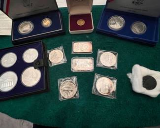 Several gold and silver coins and medallions, including an 1880 $5 gold piece, a large1835 coronet head copper penny, and several sets of Olympic silver coins. Each coin is a piece of history, perfect for collectors and history buffs alike.