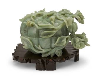 1374
20th century
A Chinese carved hardstone lidded box
The pumpkin-form box depicted with leaves and vines encircling the pumpkin and two grasshopper figures in relief, set on a custom carved and lacquered wood footed stand
Box: 6.75" H x 12" W x 9.25" D; Stand: 1.875" H x 11.5" W x 11" D
Estimate: $300 - $500