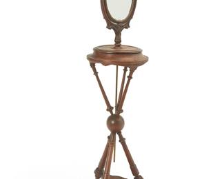 1476
Late 19th century
An Empire-style carved wood athénienne shaving mirror
The French hinged men's vanity mirror mounted with a brass rod to a tripod stand with turned supports, central ball joint, and shaped tripartite undershelf
63.75" H x 15.25" Dia.
Estimate: $300 - $500