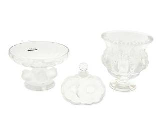 1347
Late 20th/early 21st century
Two Lalique glass figural bird vessels and flower perfume bottle
Each etched: Lalique ® France; compote with Lalique sticker; vase with sticker: Made in France
Comprising a "Nogent" compote bowl housed in original box (3.5" H x 5.25" Dia.; box: 4.875" H x 7.25" W x 7.25" D), a "Dampierre" vase (5" H x 4.75" Dia.), and a "Deux Fleurs" perfume bottle (3.5" H x 3.875" W x 1.125" D), 3 pieces
Estimate: $200 - $400