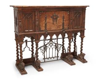 1484
Late 19th/early 20th century
A Renaissance style walnut side cabinet
The cabinet with wrought iron mounts and hinged fall front revealing a cavity with three drawers and shelves divided by arches, centering two cabinet doors, each revealing conforming cavities with two drawers, all raised on twisted standards, the anterior supports set on lion figures, joined by an openwork wrought iron stretcher
56.5" H x 73.5" W x 22.5" D
Estimate: $700 - $900