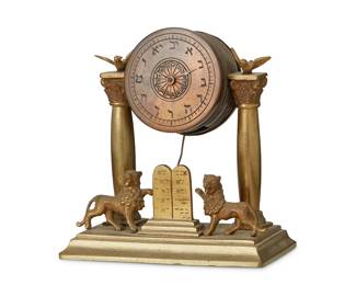 1357
20th century
A Judaica brass table clock
Unmarked
The drum-form brass single-movement clock with Hebrew numerals to dial raised between two columns on a base mounted with lions flanking two Ten Commandments tablets
4.75" H x 4.625" W x 2.625" D
Estimate: $300 - $500